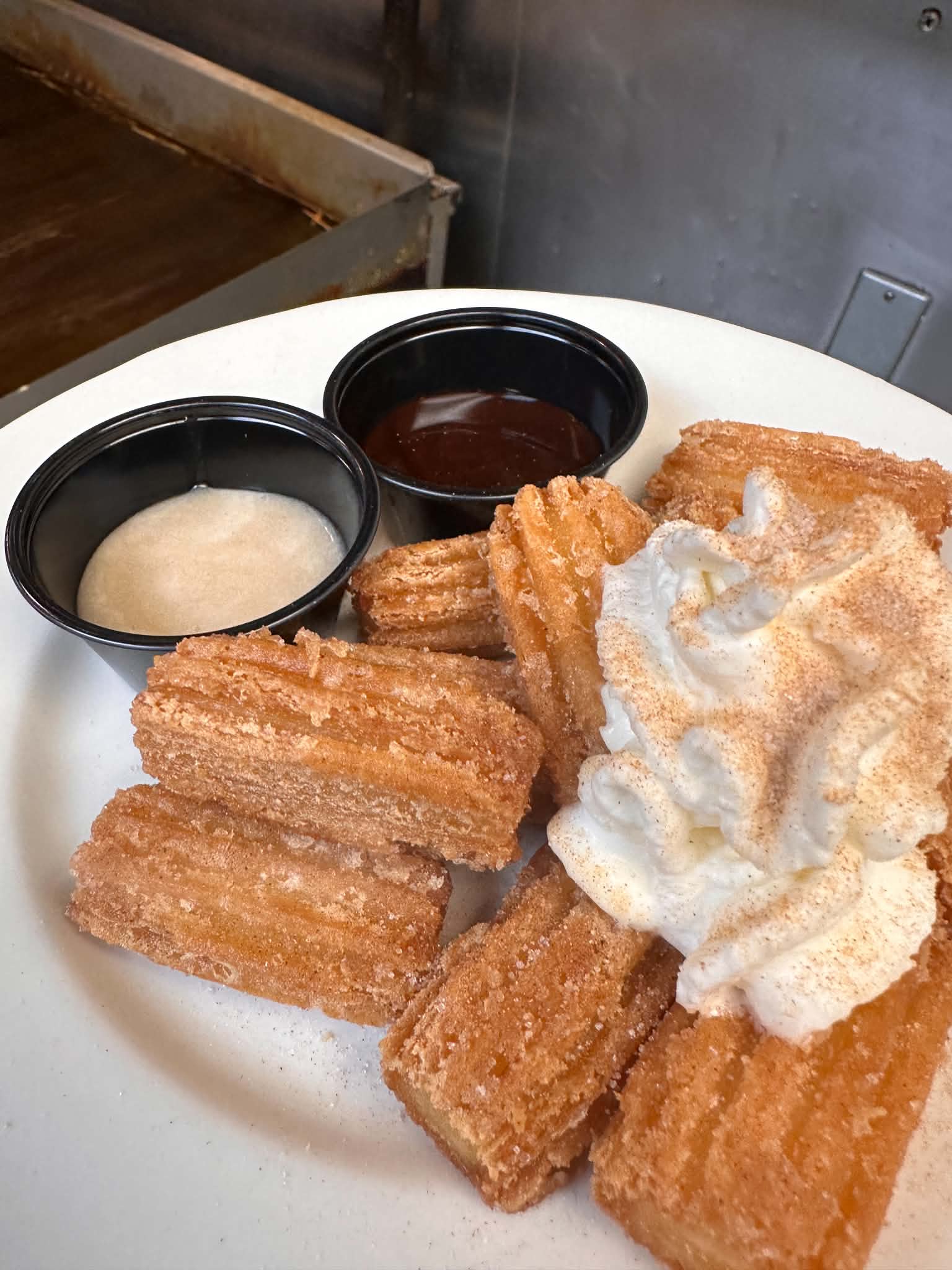 Churros with dipping sauces and whipped cream
